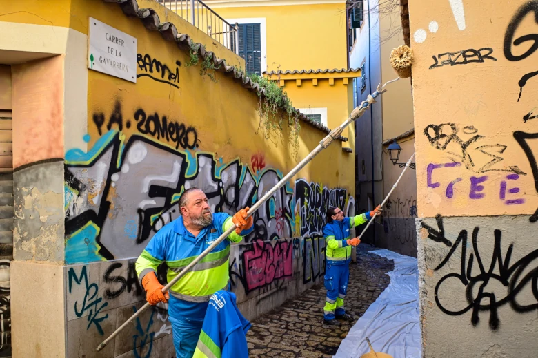 Operarios de Emaya eliminan grafitis en el barrio de Sant Jaume de Palma.